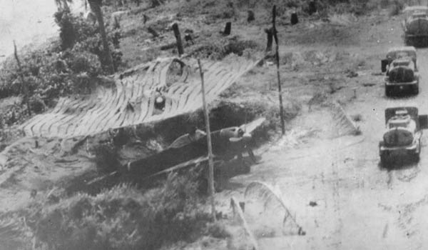 Japanese Nakajima Ki-43 Oscar parked under a camouflage net.